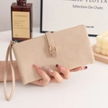 Detalle de cartera larga mate color albaricoque con hebilla metálica y correa de mano - Albaricoque