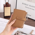 Detailed handheld view of brown lychee grain tri-fold wallet with leaf zipper and snap closure - Yellow Brown