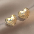 Eleganti orecchini a cuore in oro ambrato con texture in resina su seta beige - Forma a Cuore Oro Ambra (E0565)