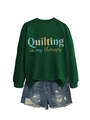Flat lay of forest green sweatshirt with Quilting is my therapy print and denim shorts - Dark Green