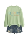 Flat lay of mint green sweatshirt with Quilting is my therapy print and denim shorts - Olive Green