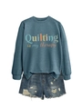 Detail of teal crewneck sweatshirt featuring colorful Quilting is my therapy print - Blue
