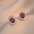 Elegante Ohrstecker mit rotem Rubin und weißen Zirkonia-Steinen auf weichem Seidenhintergrund - Rote Edelstein Ohrringe