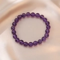 Close-up of natural purple crystal beaded bracelet on soft champagne silk fabric - Natural Amethyst Bracelet (SF0020)
