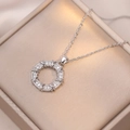 Elegante collana con ciondolo a ciambella in zirconi e acciaio al titanio su portagioie - Collana a Ciambella / Color Acciaio