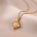 Chic gold necklace with gradient opal stone and pearl accents on silk background - Gold