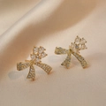 Elegant gold butterfly zircon earrings with pear-cut crystals on champagne silk background - Gold Butterfly Earrings