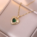 Emerald heart pendant necklace with gold chain and star accent in a jewelry box - X2440 Emerald Zircon Necklace