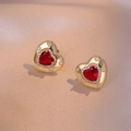 Detail of gold heart earrings with red gemstones and sparkling star engravings - E0664 Red Zirconia Earrings