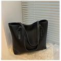 Dettaglio della grande borsa tote nera con cuciture bianche a contrasto e texture morbida - Nero