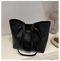 Detalle de un bolso tote grande de cuero negro con letras doradas y correa de hombro - Negro