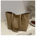 Detalle del bolso tote de cuero beige con correas ajustables y etiqueta decorativa - Caqui