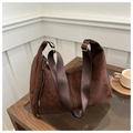 Detalle de bolso tote de ante marrón oscuro con correa ancha de nailon y herrajes dorados - café