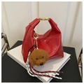Detail der roten Lederhandtasche mit Gold-Schnalle und braunem Pudel-Plüschanhänger - Mit Anhänger / Rot