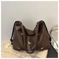 Detail der dunkelbraunen Hobo-Tasche mit goldenen Schmetterlings-Akzenten auf Strick - Braun