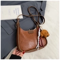Detail einer braunen PU-Leder-Hobotasche mit Teddybär-Anhänger und modischem Etikett - Mit Anhänger / Braun