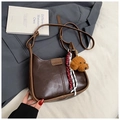 Detailansicht der Vintage dunkelbraunen Kunstleder-Halbmondtasche mit Teddy-Anhänger und Label - Mit Anhänger / Braun