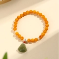 Natural amber beads bracelet featuring a green jade Buddha pendant and warm orange tones - Beeswax Buddha Beaded Style (SF0041)