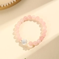 Armband aus rosafarbenen Quarzkugeln mit Silbermond und Blumenanhänger auf gelbem Podest - Rosenquarz Mond Armband (SF0030)