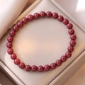 Armband aus natürlichem Cinnabarit mit tiefroten runden Perlen in einer Schmuckschatulle - Kaiserliches Zinnober-Armband