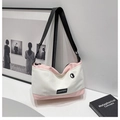 Detalle del bolso bandolera de lona en contraste con correa ajustable y logo de marca - Rosa
