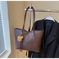 Detail of dark brown leather tote bag with vertical stitching and plush bear charm - Coffee with Pendant