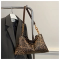 Detail of leopard print tote bag featuring a resin chain strap and gold hardware accents - Brown