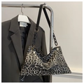 Detailed macro view of leopard print tote bag with black chain and leather strap - Black
