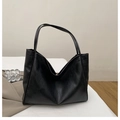Detail of black tote bag showing smooth PU leather texture and golden magnetic closure - Black