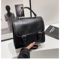 Detail view of the black retro Cambridge bag with silver buckles and leather texture - Black