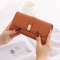 Detailed macro of caramel lychee grain leather wallet with golden metal buckle - Orange