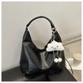 Detail of a black moon-shaped hobo bag with a white plush cloud charm on a leather chair - With Pendant / Black
