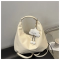 Detail of cream white PU hobo bag with cloud plush charm and embossed brand logo on the side - With Pendant / White