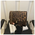 Close-up of leopard print crossbody bag with gold chain strap and metal clasp lock - Brown