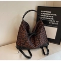 Detail einer Handtasche mit Leopardenmuster, schwarzer Schleife und Kunstlederbesatz - Braun
