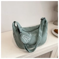 Dettaglio della borsa hobo in velluto a coste verde chiaro con ricami e mini pochette - verde chiaro