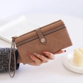 Nahaufnahme der braunen Vintage-Geldbörse mit Handschlaufe und Metallschnalle - Kaffeebraun