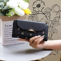 Short tri-fold wallet for women with leaf pattern and gold metal clasp in hand - Black