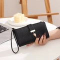 Detalle de cartera negra para mujer con colgante de hoja y correa de muñeca - Negro