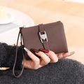 Detail einer braunen PU-Geldbörse mit Herz-Metallschnalle und praktischer Handschlaufe - Kaffeebraun