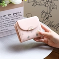 Detail van roze damesportemonnee met bladprint en elegante goudkleurige gespsluiting - Roze