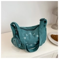 Détail d'un sac bandoulière en velours côtelé vert foncé avec sa petite pochette assortie - Vert foncé