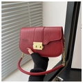 Close-up of red crocodile embossed leather handbag featuring golden metal buckle and chain - Red