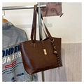 Deep brown quilted tote bag with golden buckle and woven bell charm accessory - Brown