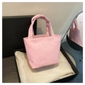 Detail of light pink mini tote bag with soft wrinkled leather texture on display - Pink
