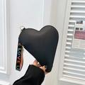 Minimalist black heart-shaped handbag with pebbled leather texture and LOVE letter strap - Black