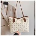 Monogram geprinte shopper in crème en bruin met lange schouderbanden in een lifestyle-beeld - Broken Wit