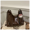 Detail der dunkelbraunen Leder-Shopper-Tasche mit silbernen Ringen und Plüschbär-Anhänger - Braun Mit Plüsch-Anhänger