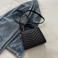 Quilted black crossbody handbag with V-shaped stitching and gold-tone hardware detail - Black