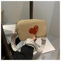 Detail of beige lychee leather crossbody bag with red heart and woven strap - Khaki